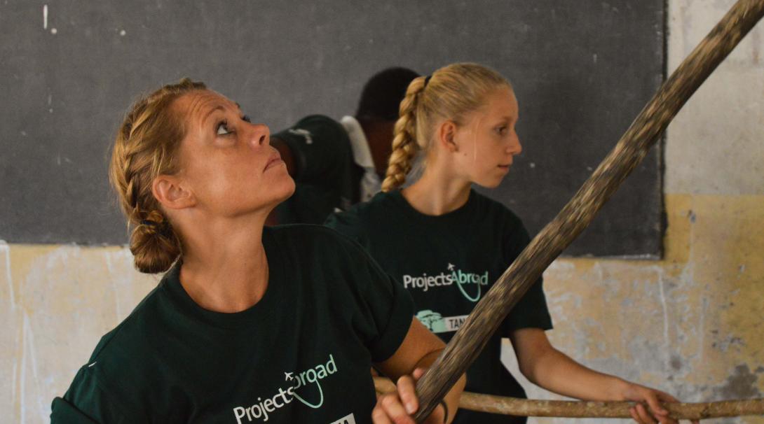Madre e hija ayudan en trabajo de desarrollo comunitario. Como parte de su voluntariado en familia, madre e hija ayudan en un voluntariado de Construcción.